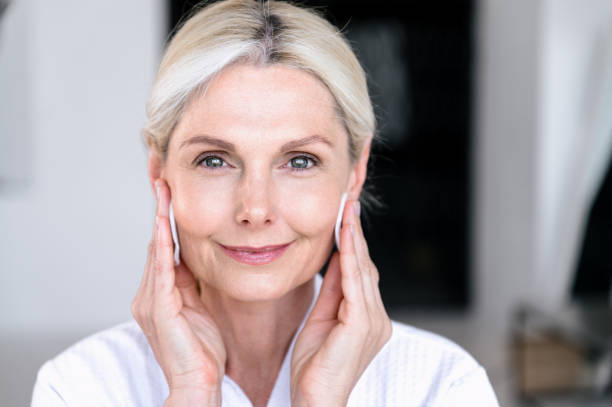 istock Middle aged woman using tonic and cleansing face with cotton pads 2153808794