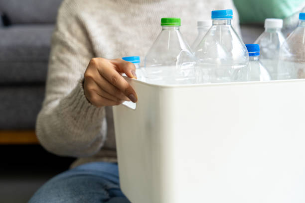 istock Asian woman sorting plastic waste in recycling bin at home 2153810843