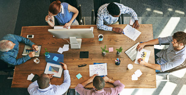 istock Business people, meeting and top view for office brainstorming with graphs, statistics or review. Men, women and conference room from above for start up planning or b2b partnership, project or charts 2153812353