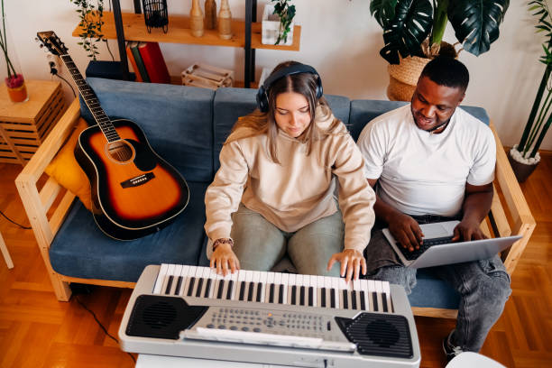 Man and woman enjoying playing instruments at home creating songs