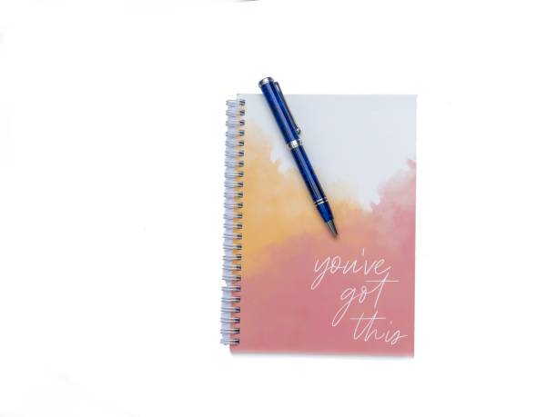 Blue Pen on a Notepad with motivational words on a white background with copy space