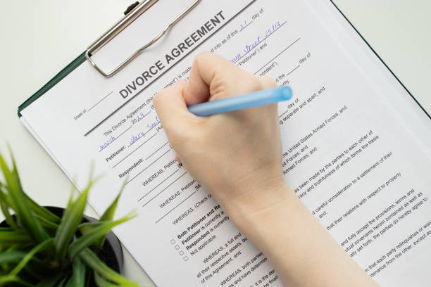 istock Divorce agreement, hand fills out a document, legal proceedings, marriage dissolution, partner signature, marriage dissolution 2153820217