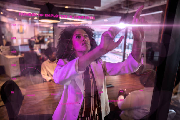 istock Young business woman using augmented reality device at office 2153822618