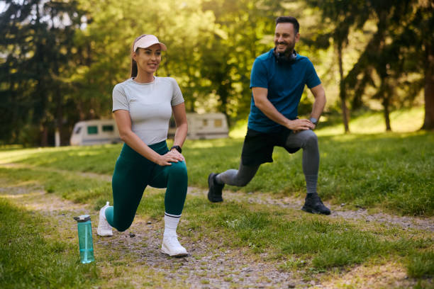 istock Athletic couple warming up while exercising together in the park. 2153823164