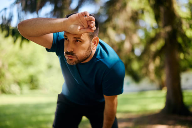istock Exhausted athletic man taking a break after running in nature. 2153823946