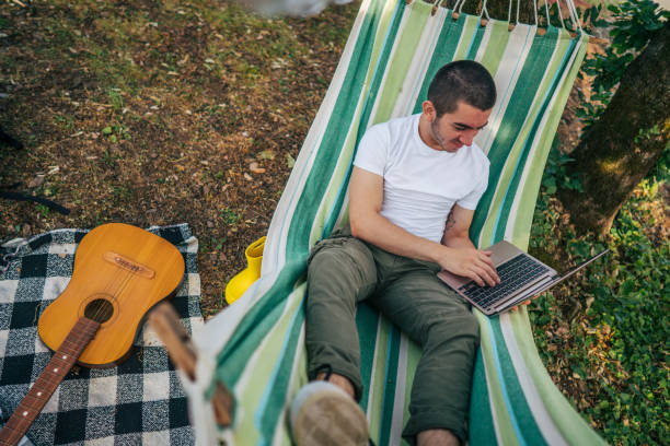 istock Happy young man working online at the countryside using a laptop computer. 2153824290