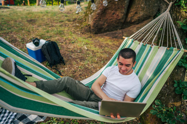 istock Happy young man working online at the countryside using a laptop computer. 2153824918