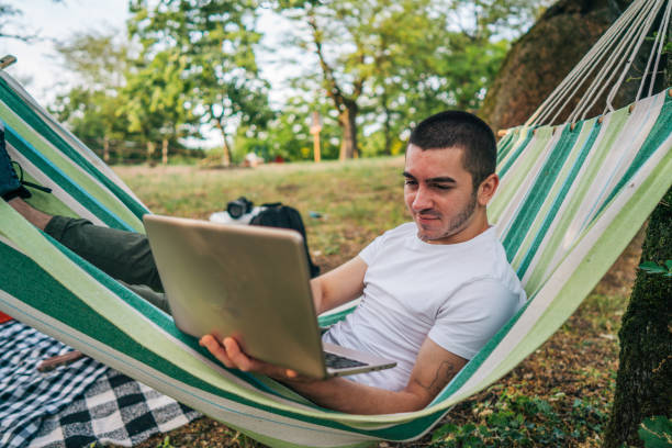 istock Happy young man working online at the countryside using a laptop computer. 2153824936