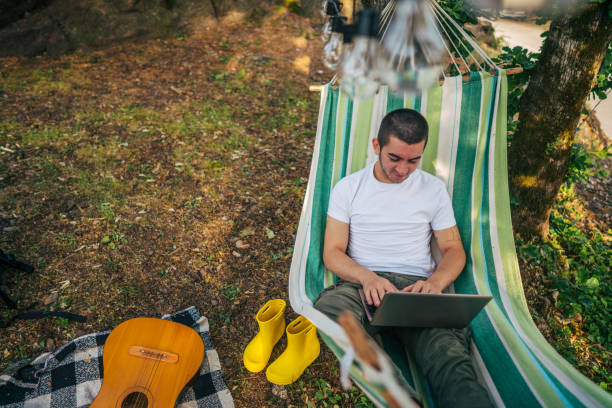 istock Happy young man working online at the countryside using a laptop computer. 2153826152