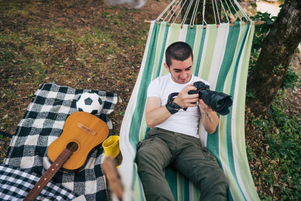 istock Young man takes photos while laying on hammock in nature 2153827583