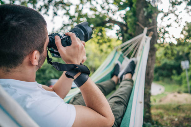 istock Young man takes photos while laying on hammock in nature 2153828057