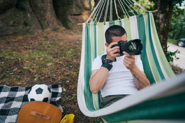 istock Young man takes photos while laying on hammock in nature 2153828270