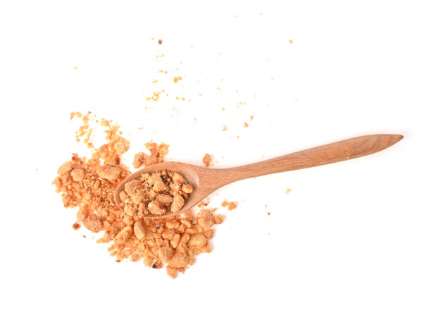 istock Crumbled Peanuts , fried peanuts, Peanut Fractions in wooden spoon isolated on White Background. top view 2153828930