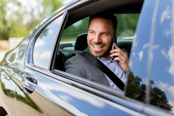 istock Joyful man sharing laughter on a phone call while driving in daylight 2153830388