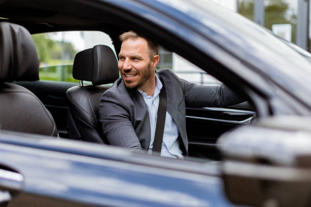 istock Smiling man enjoying a sunny drive in a modern car interior 2153830522
