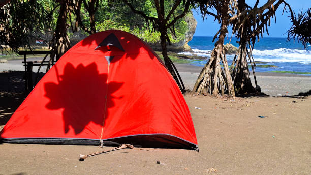 A Camping Tent with View of Madasari Beach with Coral Island with Cloudy Blue Sky Background in the Summer.