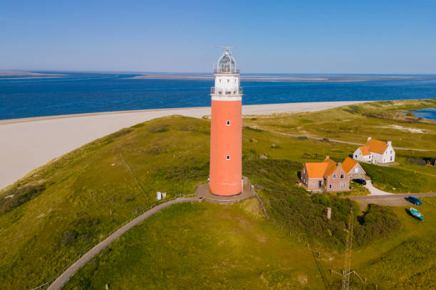 istock Majestic lighthouse overlooking a sandy beach, standing tall and guiding ships with its bright light 2153832276