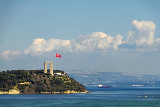 Canakkale, Turkey - Mar 18 2024: Photo of the Martyrs' Memorial in Seddulbahir village on the Gallipoli Peninsula, visible with the Aegean Sea and ships in the background.