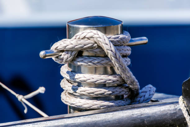 White marine rope tied in a nautical knot on the red and black steel hull of a sailing yacht