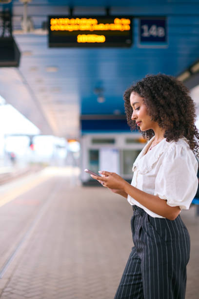 istock Businesswoman Commuting On Train Platform Using Mobile Phone For Travel Information Or Social Media 2153836395