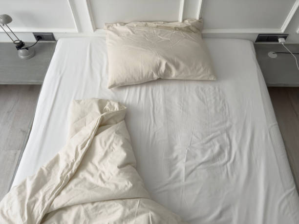 istock untidy bed with pillow and quilt in bedroom, home interior 2153841290