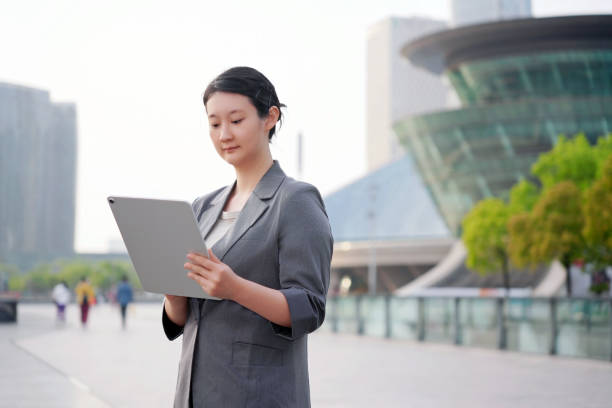 istock Professional Woman Working on Tablet Outside Office 2153841441
