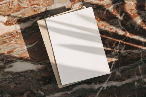 Blank greeting card, invitation, envelope mockup in sunlight from above. Colorful marble background. Red onyx texture. Harsh shadows, palm leaf overlay. Flat lay, top view. Branding template.