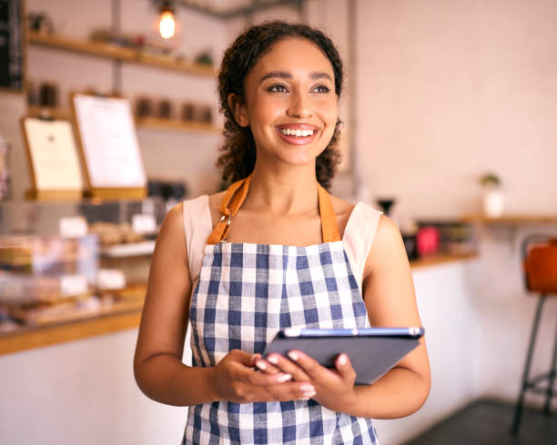 istock Young Woman Using Digital Tablet Wearing Apron Working In Coffee Shop Or Cafe 2153842355
