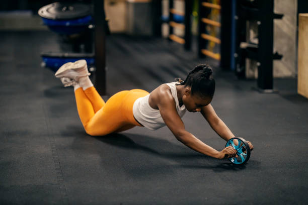 istock A fit black sportswoman is practicing with ab roller at the gym. 2153845501