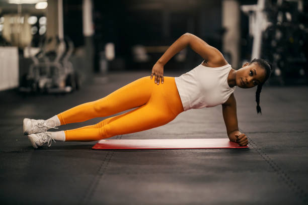 istock A fit black sportswoman doing side planks at gym. 2153845630