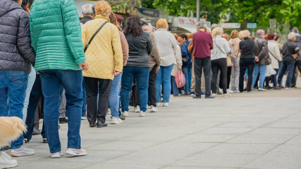 istock Long queue of people in street, back view 2153845888
