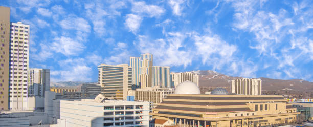 Aerial view of Downtown Reno Nevada as seen from the southeast with Hotels, Casinos, Dome buildings, an events center with mountains in the background with an overcast sky.