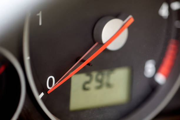 The red speedometer needle in a car shows 0 km per hour. The temperature counter shows 29 degrees Celsius.