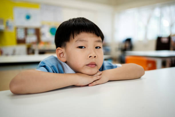 istock Kindergarten schoolboy leaning on the classroom desk 2153851420