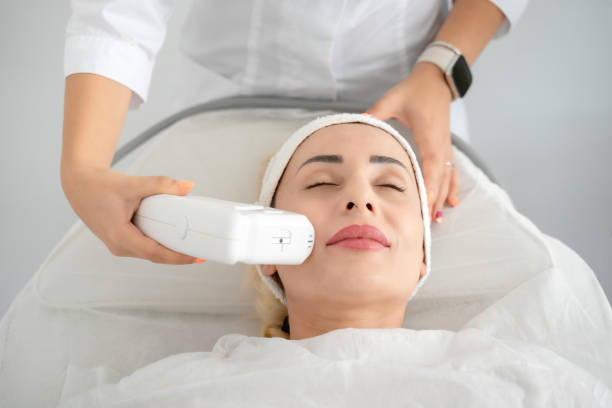 woman getting laser facial lifting therapy in beauty salon - alternatieve-therapie-fotos stockfoto's en -beelden