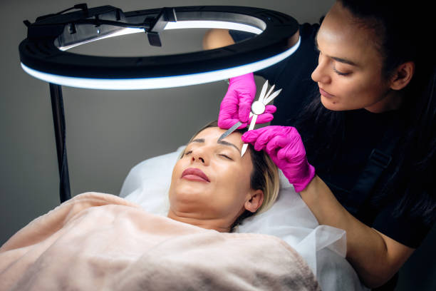 istock Beautician applying permanent make up to a customer in a beauty salon 2153854018