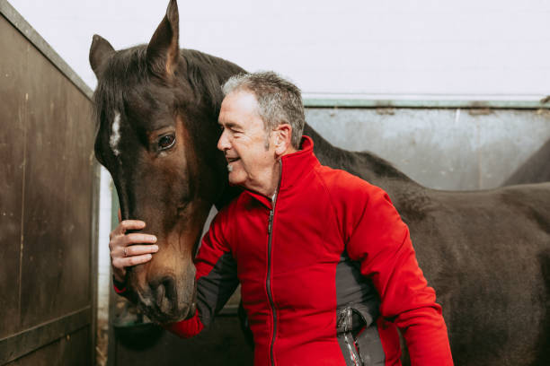 Happy man affectionately petting and caring for his horse.