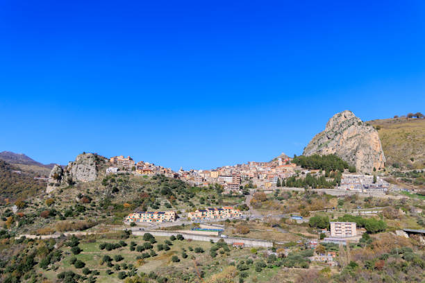 Pittoresque village de Roccella Valdemone, niché au cœur des collines siciliennes. Avec ses maisons traditionnelles sur les pentes rocheuses et son paysage verdoyant sous un ciel d'un bleu éclatant, ce village italien offre une vue imprenable et une immersion totale dans la culture méditerranéenne.