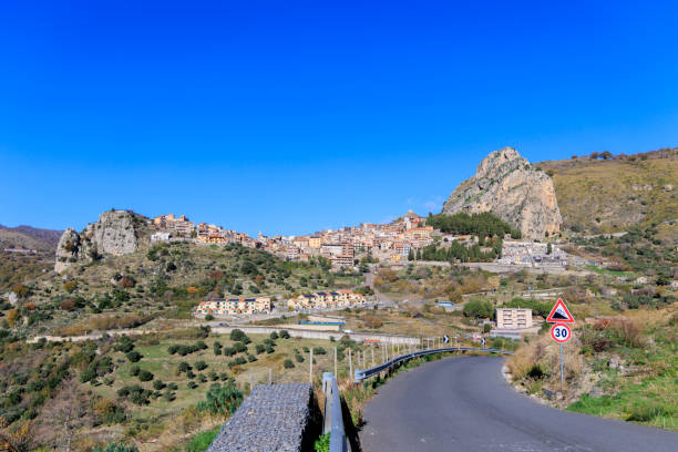Pittoresque village de Roccella Valdemone, niché au cœur des collines siciliennes. Avec ses maisons traditionnelles sur les pentes rocheuses et son paysage verdoyant sous un ciel d'un bleu éclatant, ce village italien offre une vue imprenable et une immersion totale dans la culture méditerranéenne.