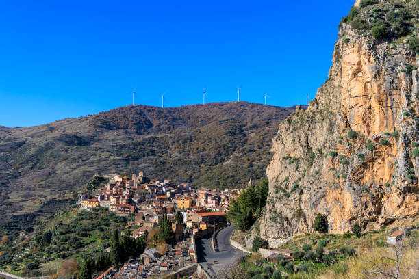 Pittoresque village de Roccella Valdemone, niché au cœur des collines siciliennes. Avec ses maisons traditionnelles sur les pentes rocheuses et son paysage verdoyant sous un ciel d'un bleu éclatant, ce village italien offre une vue imprenable et une immersion totale dans la culture méditerranéenne.