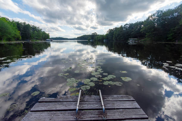 istock Looking out onto a Wisconsin lake from the end of a boat dock while  dramatic clouds are reflected in it's calm surface. 2153861198