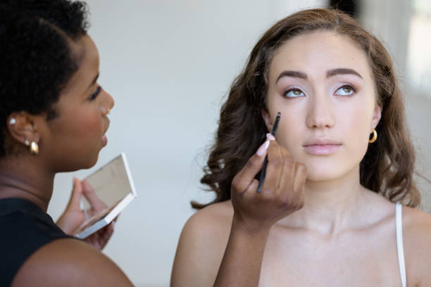 istock Makeup artist applying makeup to model 2153861850