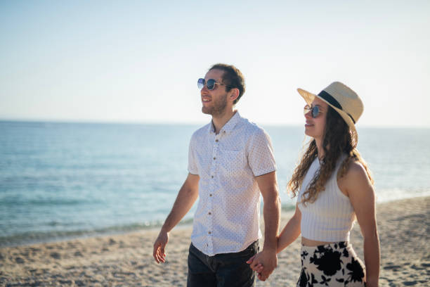 istock Couple in love walking on the beach at sunset. 2153863408