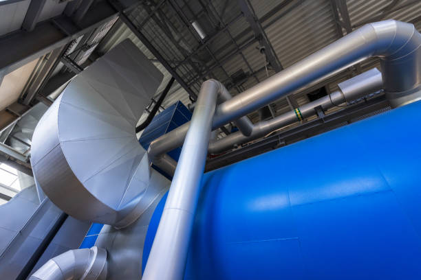 Equipment, cables and piping as found inside of a industrial power plant. Biofuel boiler