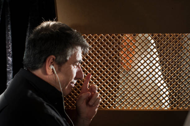 istock Priest in the confessional, with headphones 2153867188