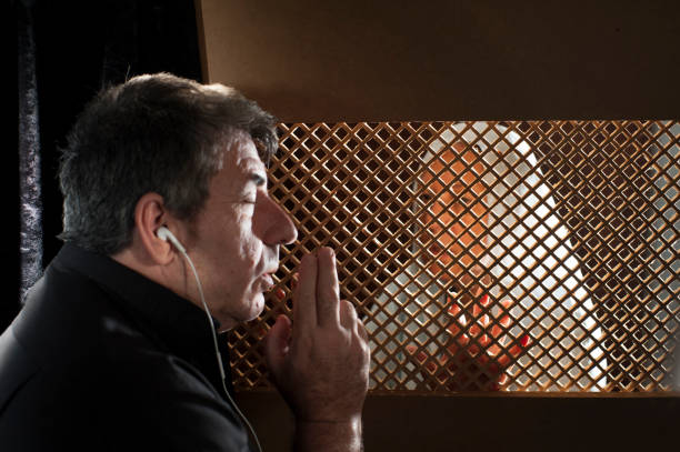 istock Priest in the confessional, with headphones 2153867190
