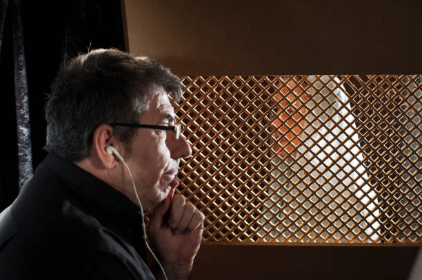 istock Priest in the confessional, with headphones 2153867191