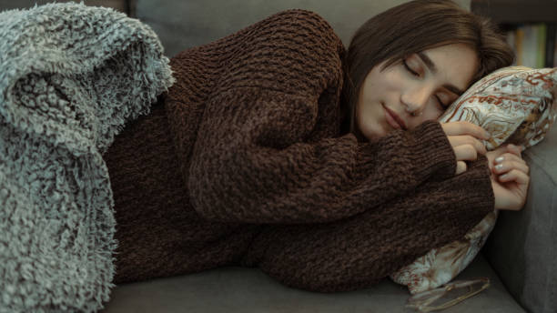 istock Cozy Woman Sleeping Peacefully on Couch 2153869258
