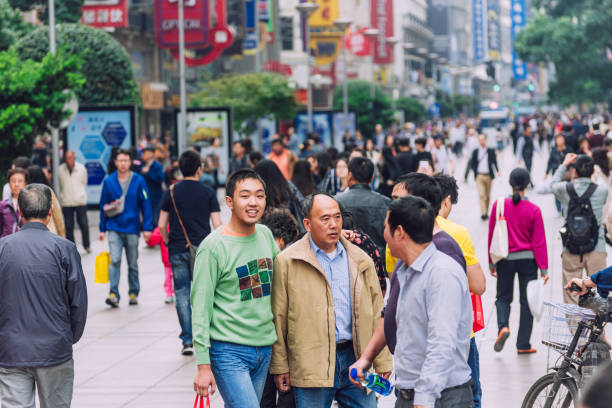 Editorial image depicting a busy pedestrian street in Shanghai, China on October 28, 2015. People are walking, shopping, and engaging in daily activities.