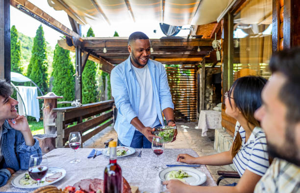 istock Man serving meal for friends in the backyard 2153875470
